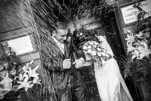 Bride and groom out of the church covered in rice