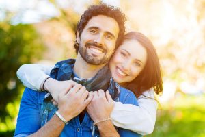 Engagement Couple hugging and smiling in nature