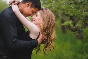 Engagement couple with foreheads touching with their eyes closed